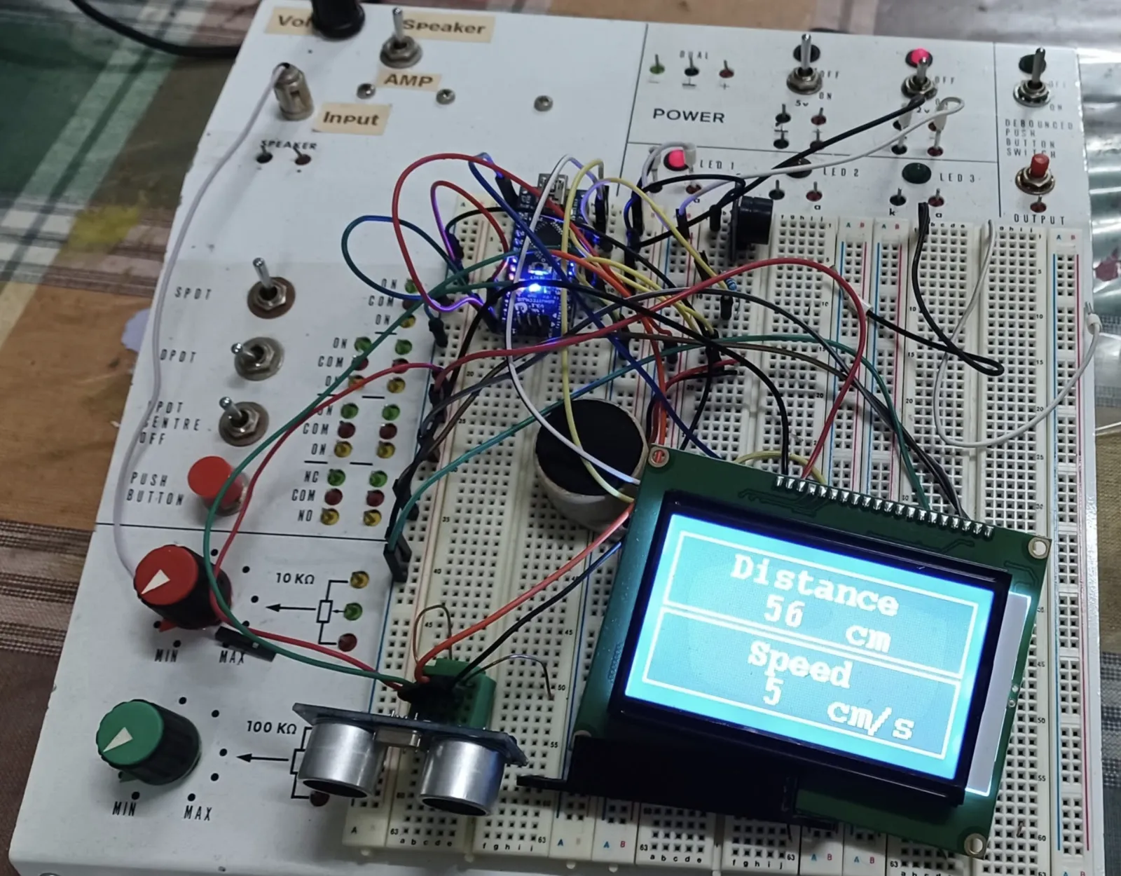 Prototyping a ultrasonic distance sensor. A rats nest of wires into prototyping board, with LCD showing the distance